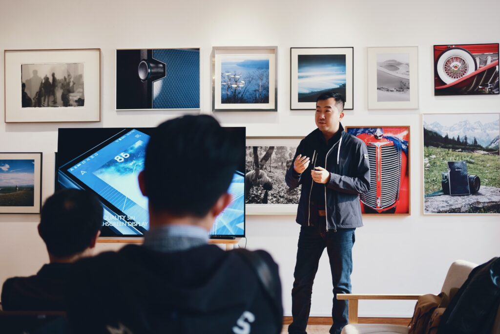 Man standing in front of a gallery of photos