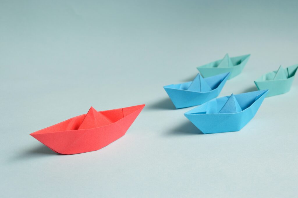 descriptive image of a flotilla of origami boats